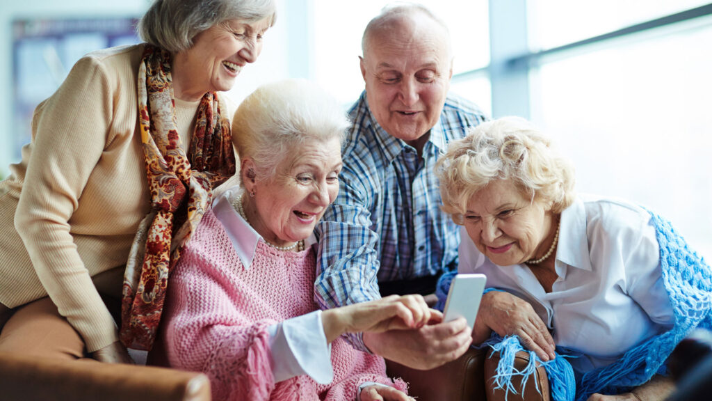 A group of residents gathering around a smartphone.