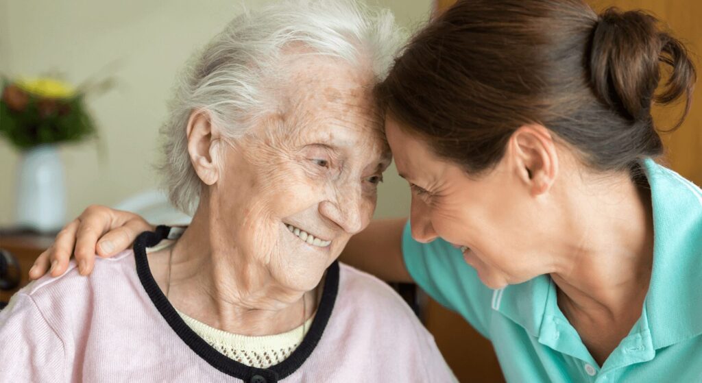 A concerned family member sitting with an elderly loved one, discussing memory care options at The Heartlands.