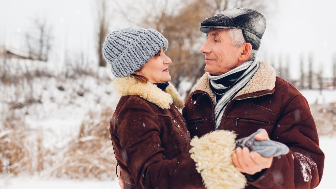 Elderly couple walking together on a winter day at The Heartlands senior living in Marlette, MI.